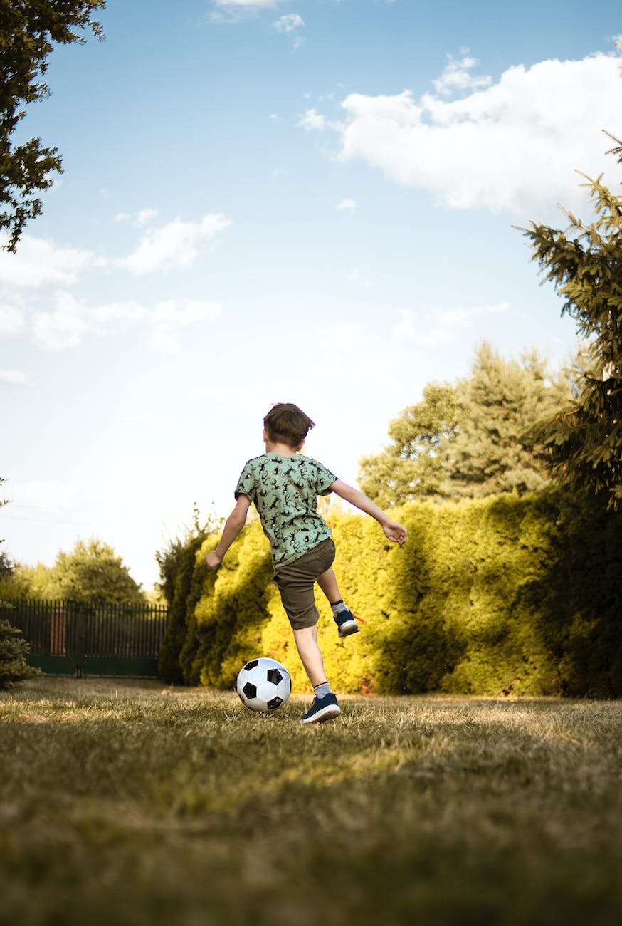 low angle photo of a boy playing soccer